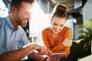 A man and a woman search the web together on a phone